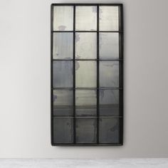 a black framed mirror hanging on the wall