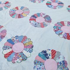 a quilted table cloth with many different designs on it, including pink and blue circles