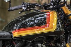 a close up view of the front end of a black motorcycle with yellow and red stripes