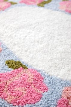 an area rug with pink and blue flowers on the bottom is shown in close up