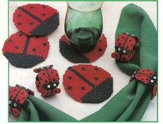 the ladybug coasters are made out of plastic and have matching green napkins