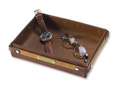 a pair of sunglasses and watch sitting in a leather case