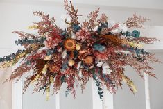 an arrangement of dried flowers hanging from the ceiling