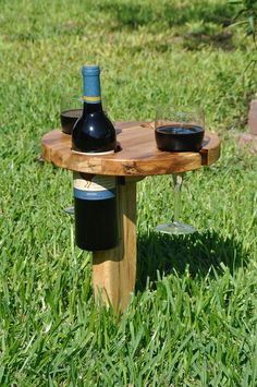 a wooden table with two bottles of wine on it and a glass of wine in the middle