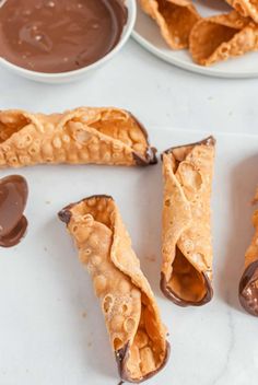 chocolate filled pastries on white plates with spoons