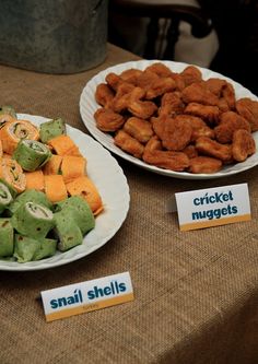 two plates filled with food sitting on top of a table next to another plate full of fried nuggets