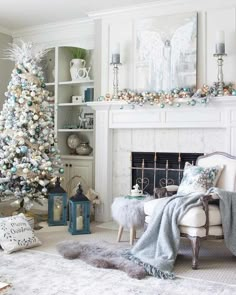 a living room decorated for christmas with a white tree and silver ornaments on the mantle