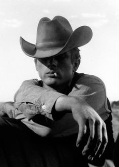 black and white photograph of a man wearing a cowboy hat with his hand on his hip