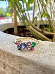 This 18ct yellow gold cluster ring features a stunning multicolor sapphire for a tot of .9ct with a stunning blue sapphire at its center and one radiating emerald (.11ct) for a colorful eye-catching look. Expertly set in a timeless classic yellow gold, bringing a colorful touch to your everyday style. Available in Size 6.5US and can be adjusted to fit your requested size. Please leave your comments at checkout 1 piece is available of this ring & cannot be replicated due to the availability/rarity of the stone/cut/ct weight. Metal: Genuine authenticated solid 18Kt yellow gold Not plated or filled or vermeil 750 Stamped for authenticity Gemstone: Multicolor Sapphire tot .90ct Emerald 0.11ct Handcrafted in Dubai If you wish to customize same ring with a similar/different stone please get in t Multicolor Sapphire Multi-stone Ring, Multicolor Multi-stone Sapphire Ring, Multicolor Sapphire Ring In Fine Jewelry Style, Multicolor Multi-stone Birthstone Ring Fine Jewelry, Multicolor Sapphire Gemstone Ring, Rainbow Sapphire Ring As Gift, Rainbow Sapphire Ring Fine Jewelry Gift, Multicolor Gemstone Birthstone Ring In 14k Gold, Rainbow Sapphire Ring For Gift