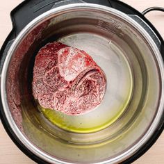 raw meat in an electric pressure cooker with oil and seasoning on the side