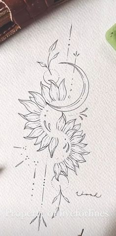 a drawing of a sunflower on paper next to some pens and inking supplies