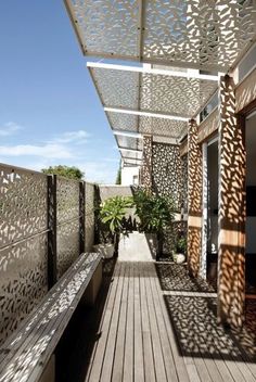 a long wooden bench sitting under a pergolated covering on top of a building