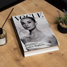 a magazine sitting on top of a wooden table next to a jar of lavenders