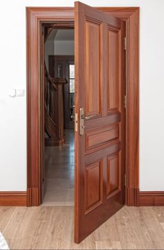 an open wooden door in a white room