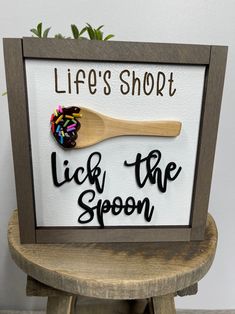 a sign that says life's short lick the spoon with sprinkles on it