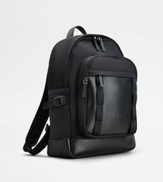 Backpack in fabric and leather, with handle strap and adjustable shoulder straps. Closed with a double-slider zip, it comes with a small front compartment, featuring a zipped pocket. The flat side pockets are emphasized by a band with metal buckle. A refined synthesis of artisanal taste and functionality. Luxury Commuting Bags With Leather Trim, Luxury Bags With Leather Trim For Commuting, Black Leather Backpack With Leather Trim For Travel, Black Bag With Leather Trim For Commuting, Black Leather Backpack With Leather Trim, Classic Black Nylon Backpack, Luxury Nylon Backpack With Leather Trim, Black Backpack With Leather Trim For Travel, Classic Black Bag For Commuting