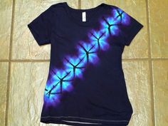 a t - shirt with blue and purple swirls on it sitting on a tile floor