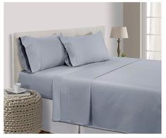 a bed with blue sheets and pillows on it