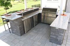 an outdoor kitchen with granite counter tops and stainless steel appliances on the outside patio area