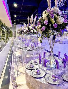 the tables are set with purple and white flowers