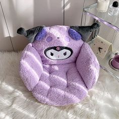 a purple chair with an animal face on the front and back, sitting on a fluffy white rug