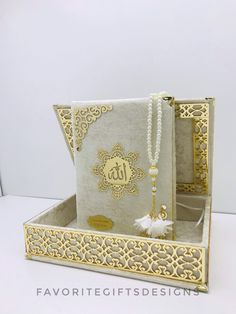 an open gift box with a tassel hanging from it's side and the lid opened