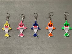 six different colored key chains with an image of a cartoon character on one side and the other