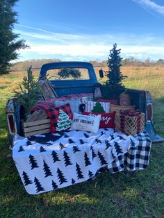 an old pickup truck with christmas decorations in the bed and blanket on it's back