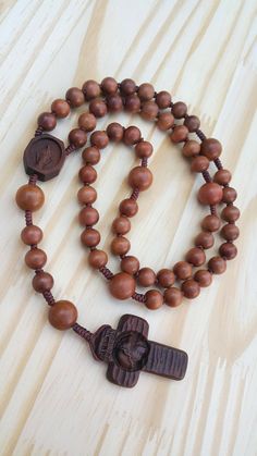 +. This is an wooden rosary. +. I carved an Crucifix and Medal in wood with great delicacy. +. The Crucifix is elaborately engraved on face of Jesus. +. The Medal of the Virgin Mary was also carved exquisitely. +. The rosaries are all made of wood. So, if you touch it with your hands, the wood will have a natural polish. +. +. +. Material +. +. +. Crucifix & Medal : surinam ebony beads : jujube tree +. +. +. Size +. +. +. Crucifix : 31mm(width) * 46mm(height) Beads :10mm&13mm +. Carved c Meditation Rosary With Wooden Beads And Cross Shape, Brown Wooden Beaded Cross Rosary, Wooden Beads Rosary With Crucifix As Gift, Gift Rosary With Wooden Beads And Crucifix, Brown Cross-shaped Rosary With Wooden Beads, Brown Rosary With 8mm Beads, Brown Rosary With 8mm Beads And Cross Shape, Jujube Tree, Knotted Rosary