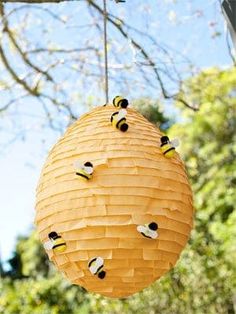 a beehive hanging from a tree with bees on it