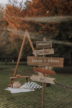 a wooden sign sitting on top of a lush green field