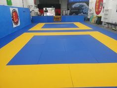 an indoor gym with blue and yellow mats