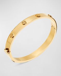 Stainless steel bracelet from Tory Burch. Silvertone, golden or rose golden plating. Signature double-"T" logo studs. Approx. 0.28"W; 2.4" diameter. Hinged opening eases dress. Imported. Luxury Gold-plated Tarnish-resistant Bracelets, Luxury Gold Tarnish-resistant Bracelet, Tory Burch Hoop Earrings, Tory Burch Jewelry Gold, Tory Burch Bracelet, Tory Burch Outfit, T Logo, Tory Burch Miller, Hinged Bracelet