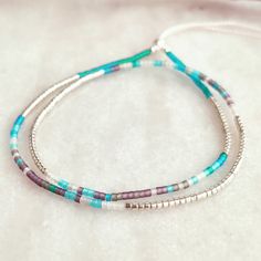 This delicately-strung exclusively crafted bracelet has a mix of Sterling Silver 2mm beads and tiny Japanese Miyuki glass beads in galvanized Silver and a mix of frosted/matte beach glass colours. It is finished with a Sterling Silver filled sliding clasp to adjust to your size. Wear this alone or layer and stack with other beaded tones for a fun yet elegant look. A great holiday essential that goes with everything. Treat yourself or spoil someone special! All items come ready for gifting carefully packaged in pretty sparkly tissue paper and a lovely jute bag with seaside charm. A white logo'd gift box is available for a small additional cost. Please select from variations. Why not browse our shop and take a look at our other listings. www.etsy.com/uk/shop/CraftyCurlewStudio Item Details - Dainty Sterling Silver Bracelets With Tiny Beads, Dainty Sterling Silver Bracelet With Tiny Beads, Minimalist Beaded Sterling Silver Bracelet As Gift, Dainty Sterling Silver Beaded Bracelets With Tiny Beads, Bohemian Silver Friendship Bracelets With Tiny Beads, Silver Friendship Bracelets With Tiny Round Beads, Minimalist Silver Friendship Bracelets With Tiny Beads, Minimalist Silver Friendship Bracelet With Tiny Beads, Adjustable Sterling Silver Beaded Bracelets With Colorful Beads