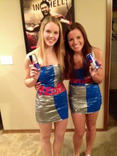 two girls dressed in silver and blue posing for the camera, one is holding cans