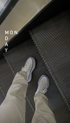 a person standing in front of an escalator with their feet on the ground