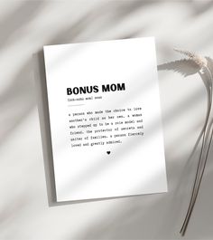 a piece of paper with the words'bonus mom'written on it next to a plant