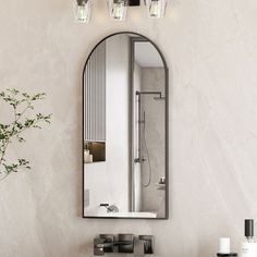 a bathroom sink sitting under a mirror next to a vase with flowers on top of it