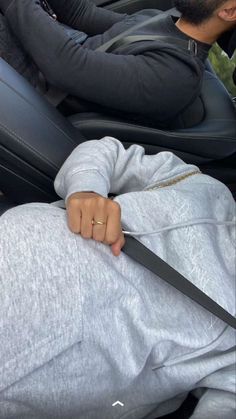 a man sitting in the back seat of a car while holding onto a large pair of scissors