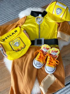 a child's costume and shoes are laid out on the floor