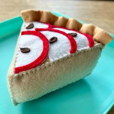 a slice of pie with red and white designs on it sitting on a blue plate