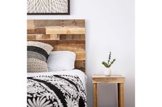 a wooden headboard made out of pallet wood with a plant on the side