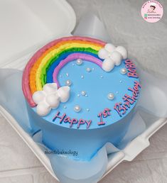 a blue birthday cake with a rainbow on it