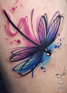 a colorful dragonfly tattoo on the thigh