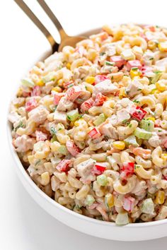 a bowl filled with macaroni salad on top of a white table