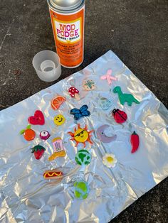 a can of spray paint next to some cut out magnets on a piece of tin foil