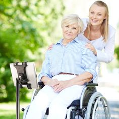 an older woman sitting in a wheelchair with her arm around the younger woman's shoulder