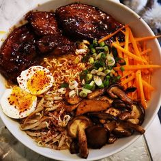 a bowl filled with meat, vegetables and an egg