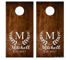 two wooden door hangers with the initials and laurels on them, one for each family member