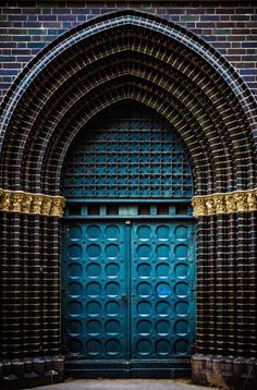 a large blue door with gold trim on it's sides and an arched doorway